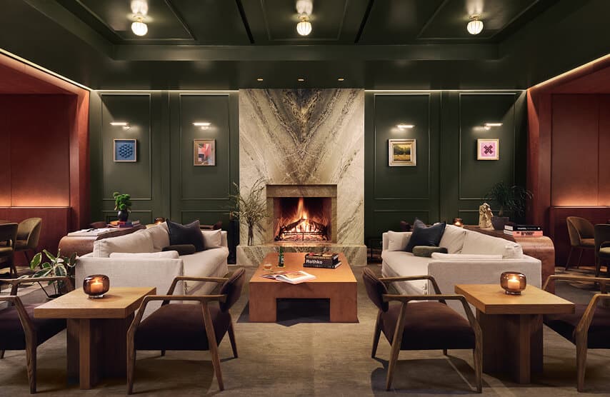 Cozy modern lounge with sofas and a lit fireplace in a stylish interior setting