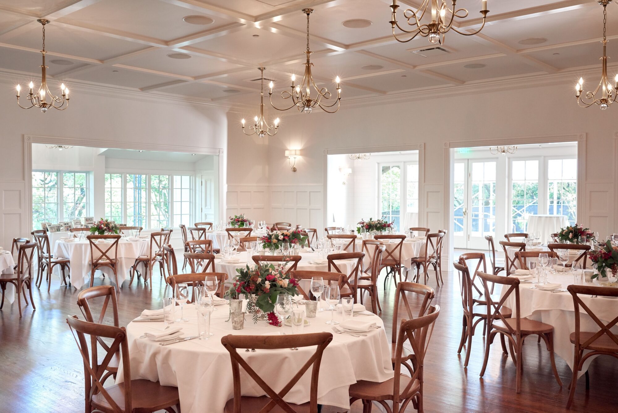 Elegant wedding reception hall with round tables and floral centerpieces