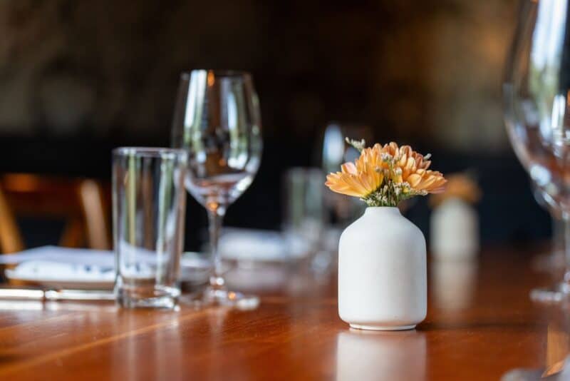 Elegant restaurant table with flowers in a vase and glassware