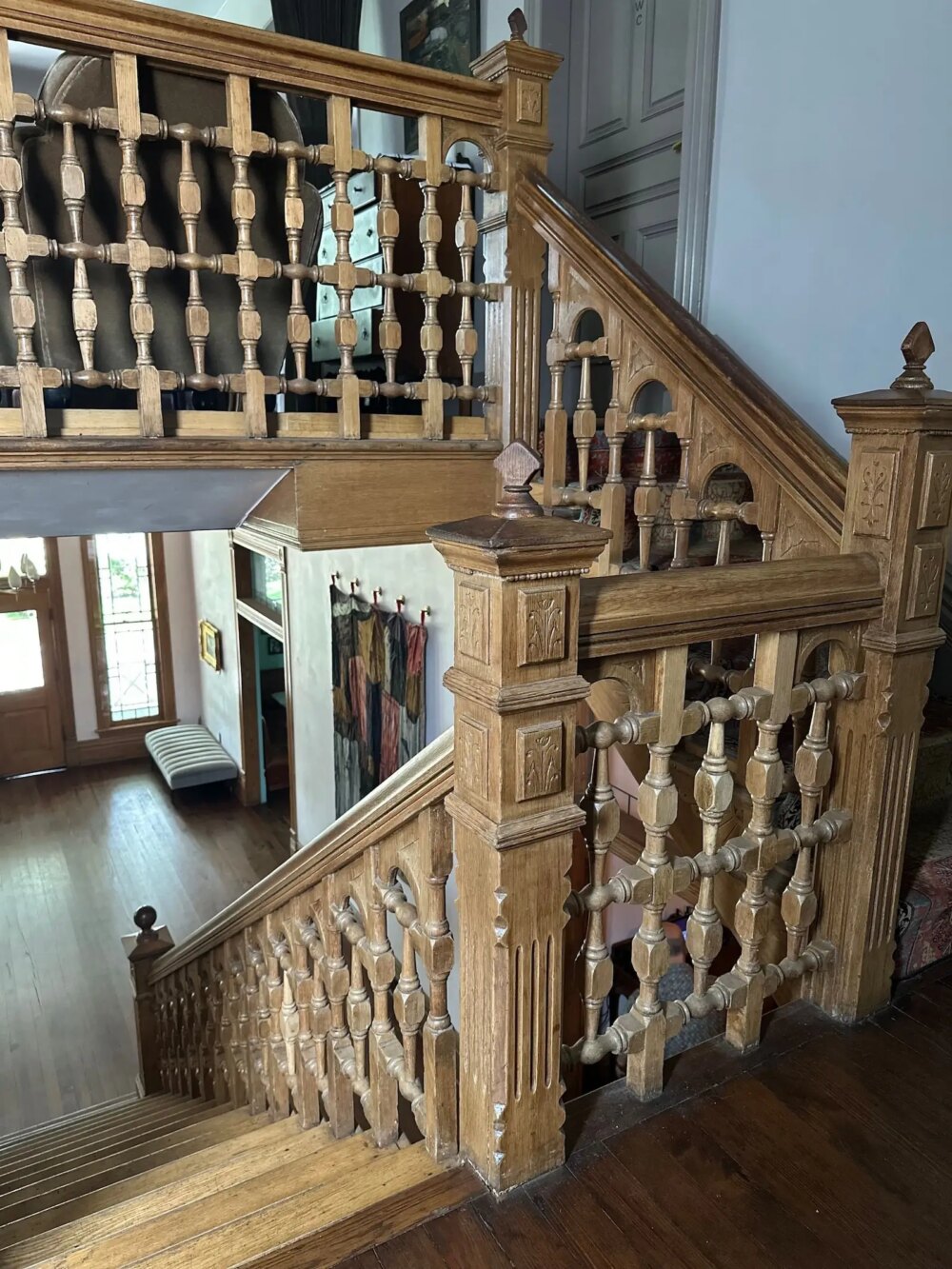 Ornate wooden staircase with intricate railings in a bright, spacious home interior