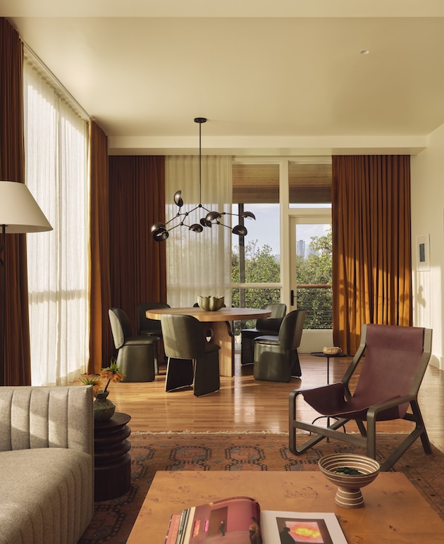 Stylish living room with large windows and modern furniture in warm tones