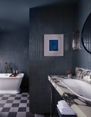 Modern bathroom with freestanding tub blue tiled walls and marble countertop sink