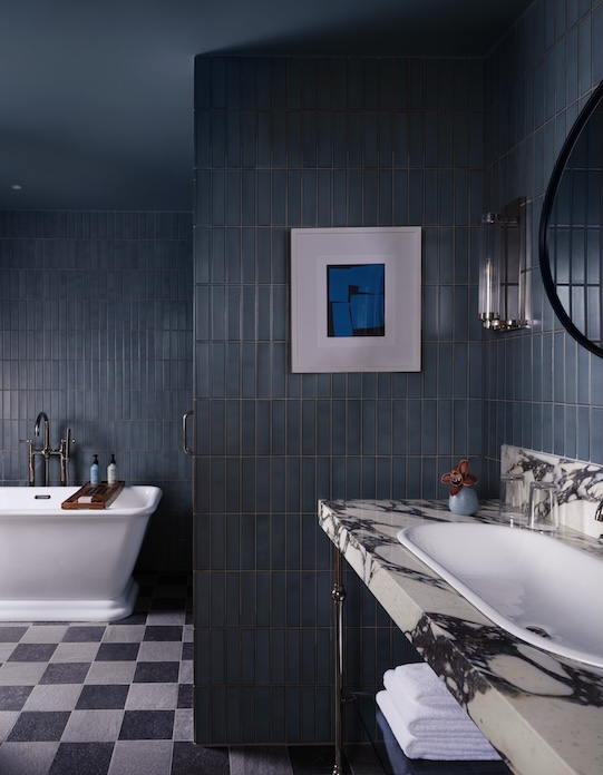 Modern bathroom with freestanding tub blue tiled walls and marble countertop sink