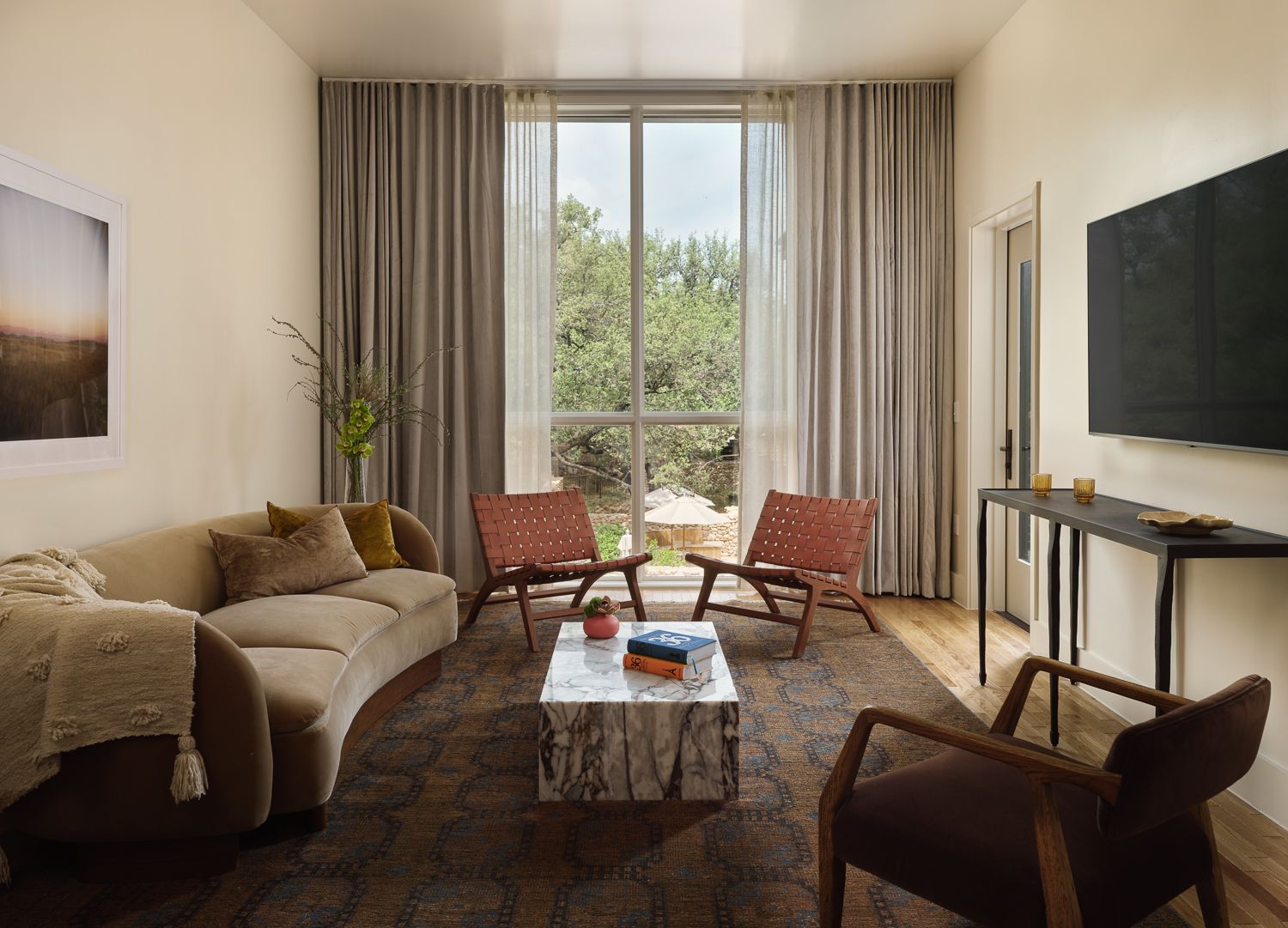 Modern living room with large window sofa chairs and marble coffee table