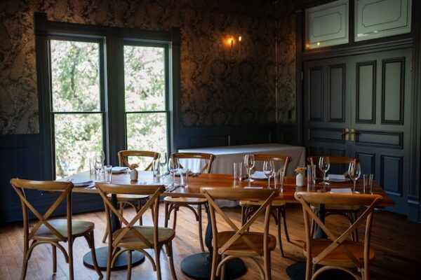 Cozy rustic dining room with wooden tables and chairs near large windows